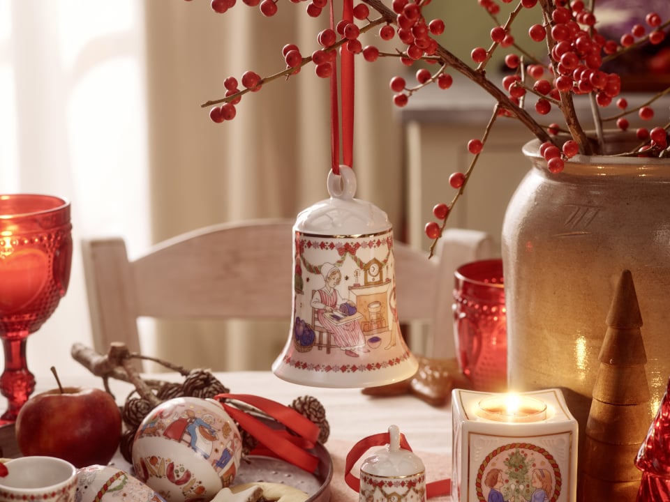 Cloche de No&euml;l suspendue &agrave; une branche au-dessus d'une table d&eacute;cor&eacute;e pour No&euml;l.
